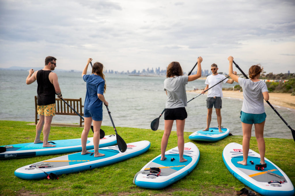 A group of people learning to SUP on land preparing for their eco tour