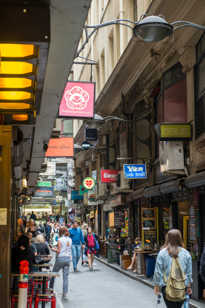 A narrow street with various restaurants and cafes