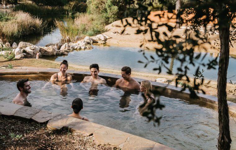 Group of adults bathing and chatting in hot pool